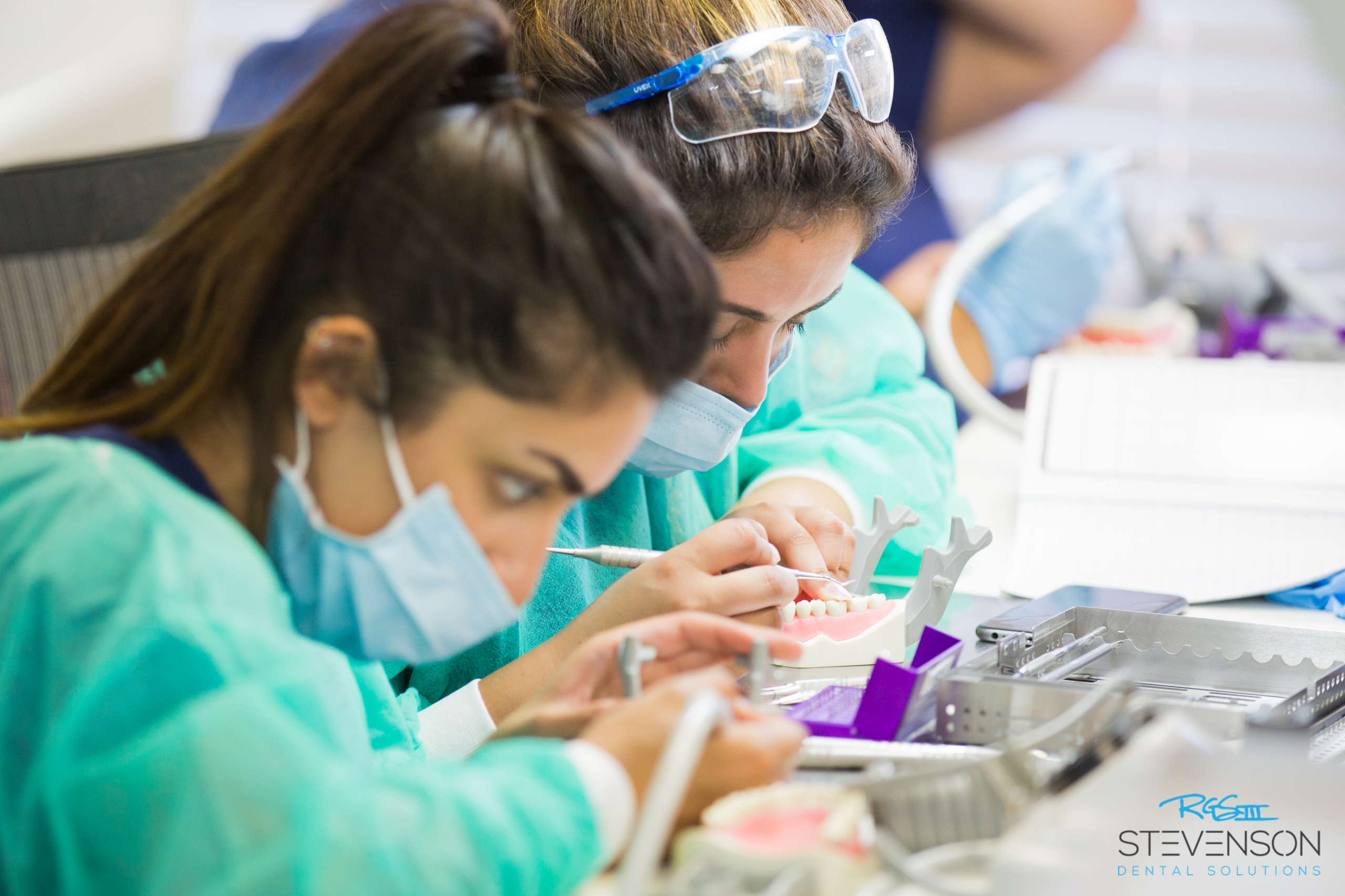 International dentists practicing bench exam tooth preparation during hands-on training at Stevenson Dental Solutions