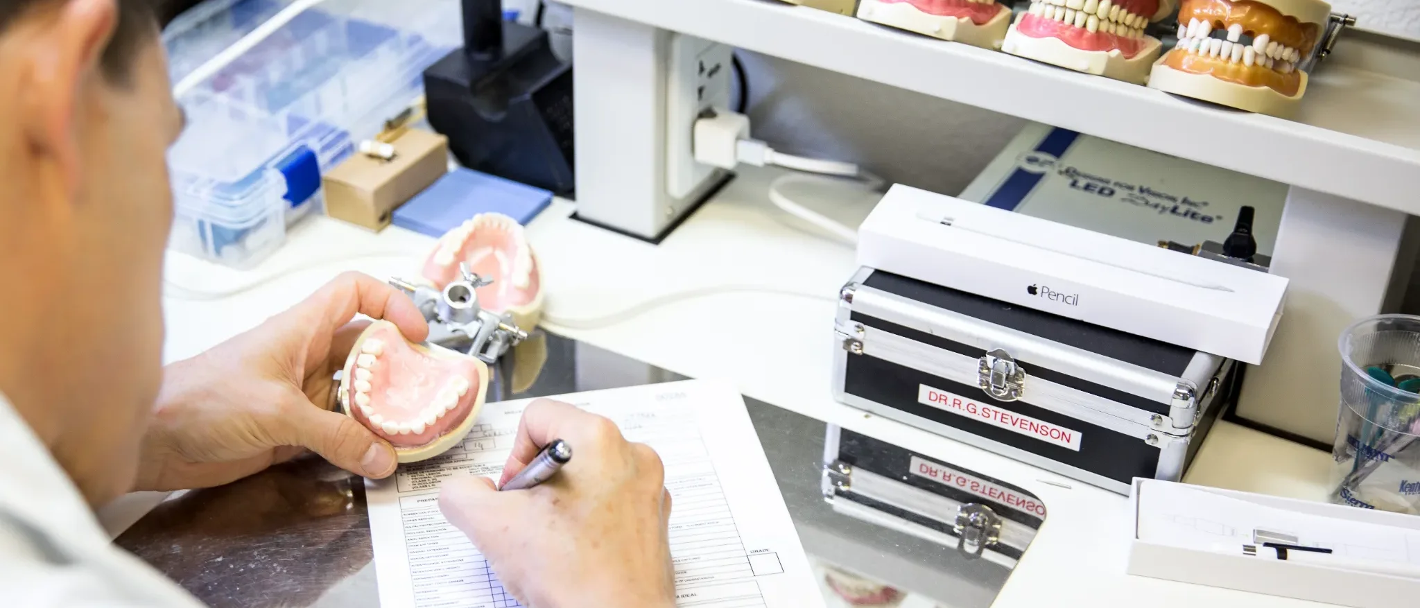 Dr. Richard Stevenson evaluating a dental bench exam model during hands-on preparation